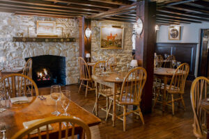 Cozy interior of The Red Fox Inn & Tavern with stone fireplace and wooden furniture, perfect for a w.