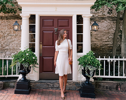 Charming Woman at The Red Fox Inn & Tavern Elegant woman standing in front of The Red Fox Inn & Tavern entrance, showcasing historic architectu.