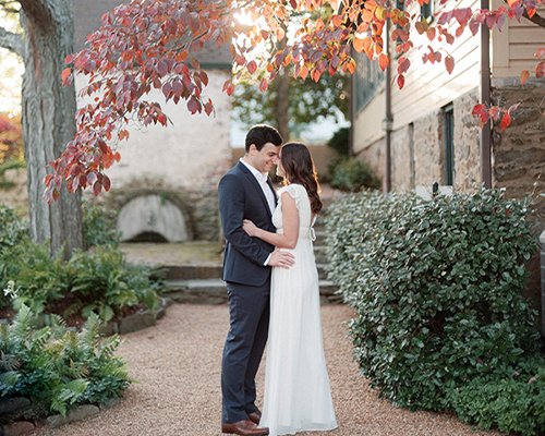 Red Fox Inn & Tavern romantic outdoor wedding scene Romantic couple in wedding attire standing under autumn trees at The Red Fox Inn & Tavern.