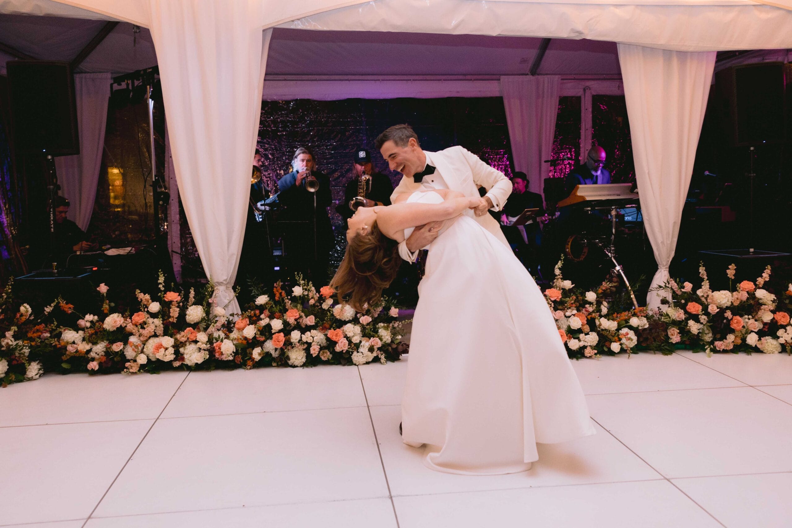 Bride and groom sharing a romantic dance under a decorated canopy.