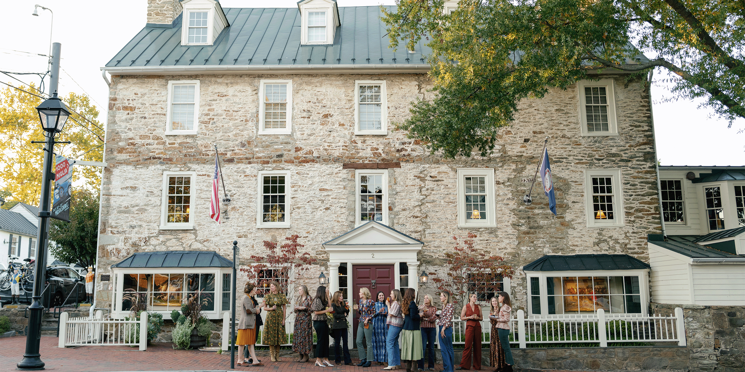 Historic Red Fox Inn & Tavern with guests on the porch, inviting atmosphere.