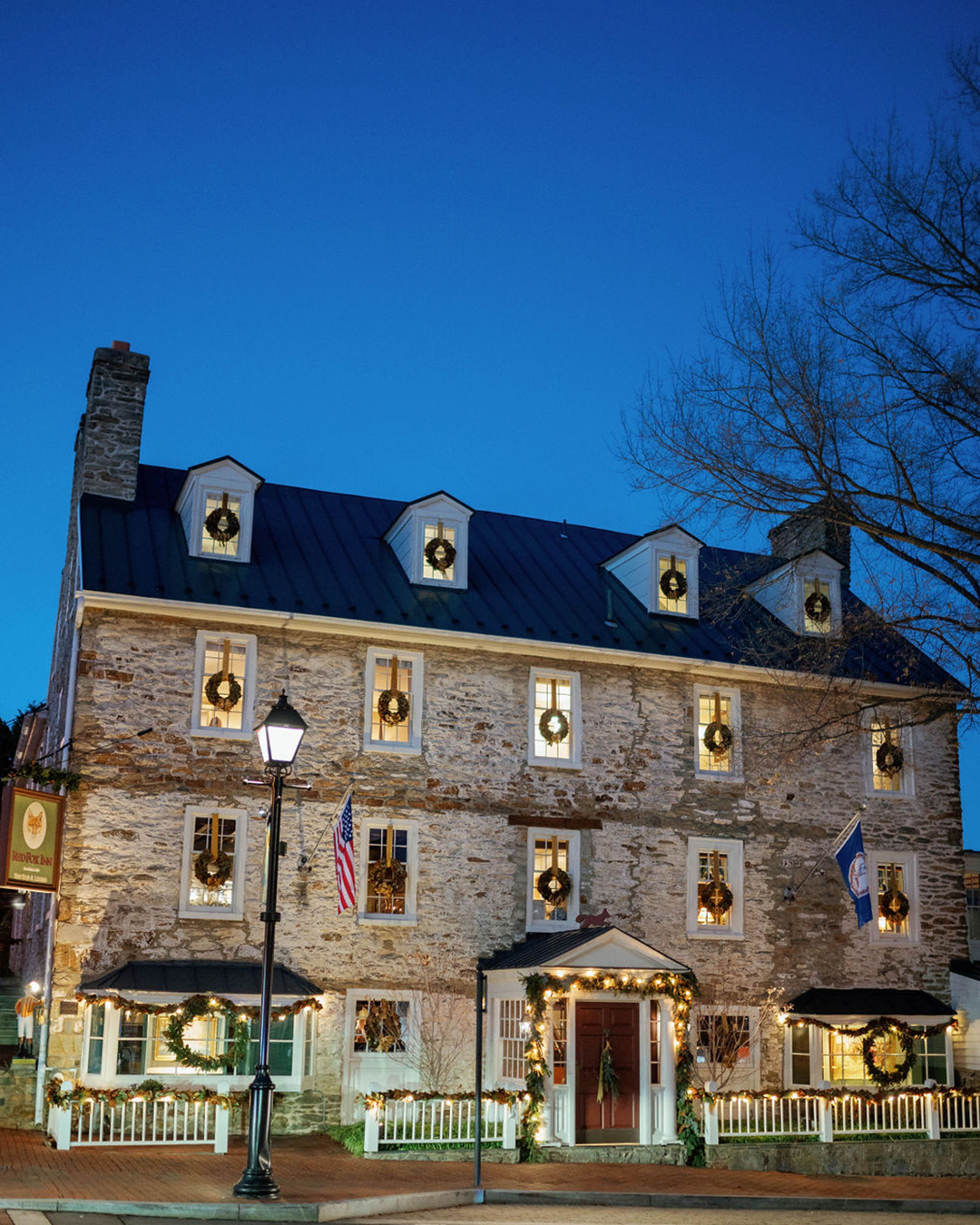Historic inn decorated with festive wreaths and lights for the holidays.