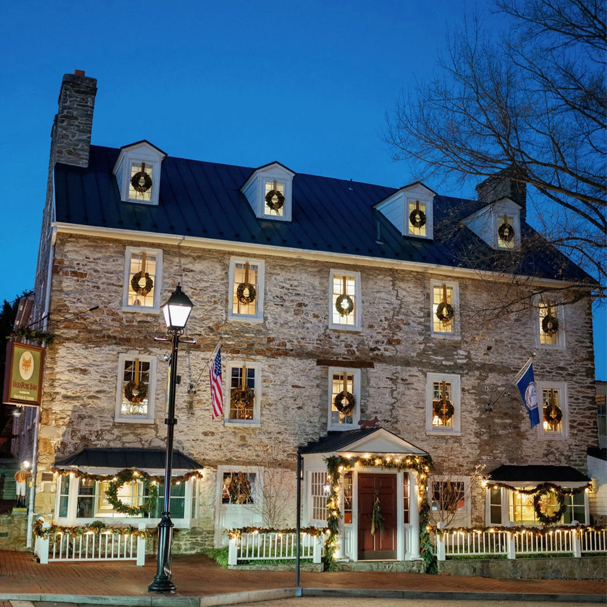 Historic inn decorated with festive wreaths and lights for the holidays.