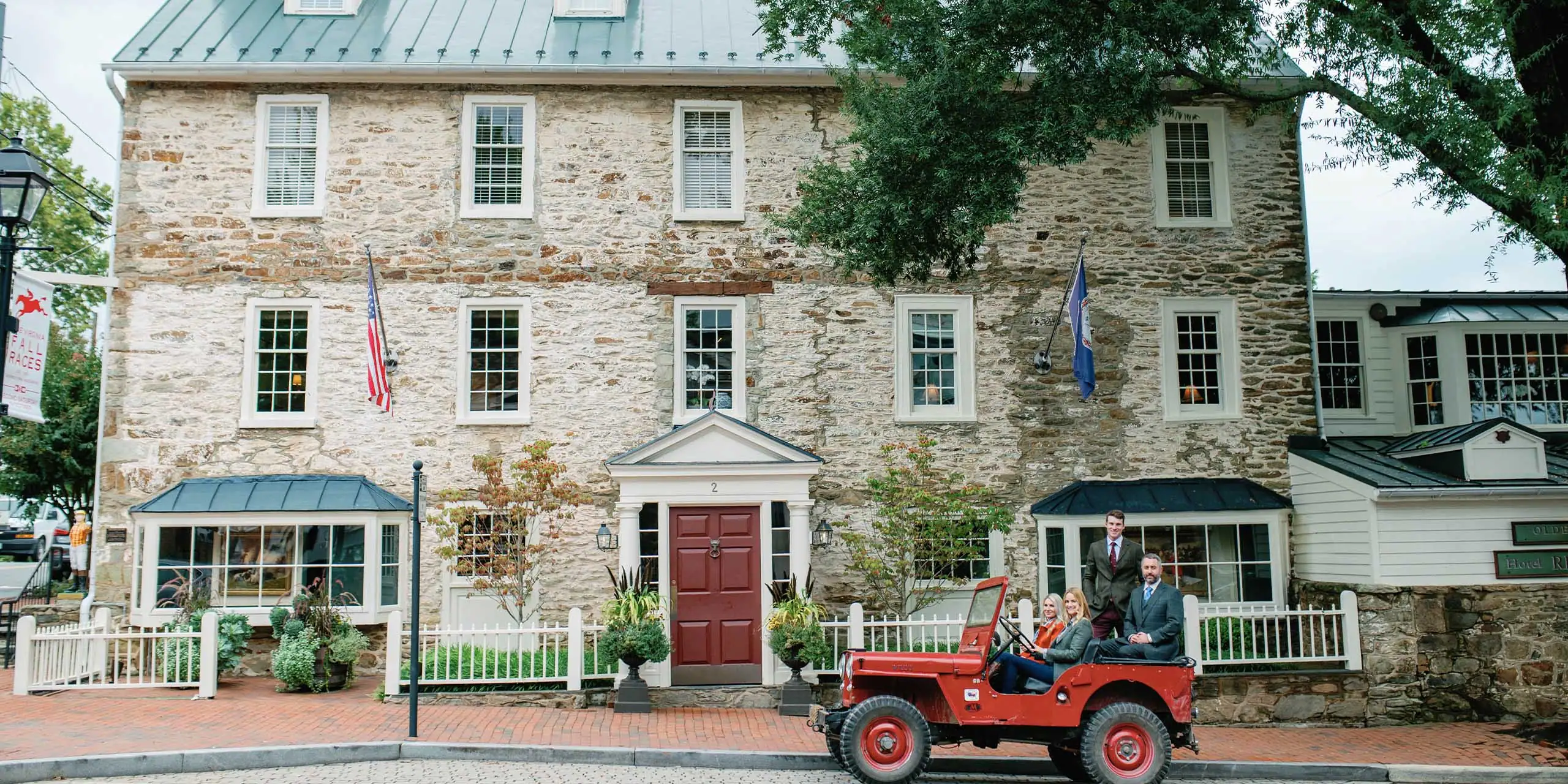 Charming exterior of The Red Fox Inn & Tavern with festive flags and lively atmosphere.
