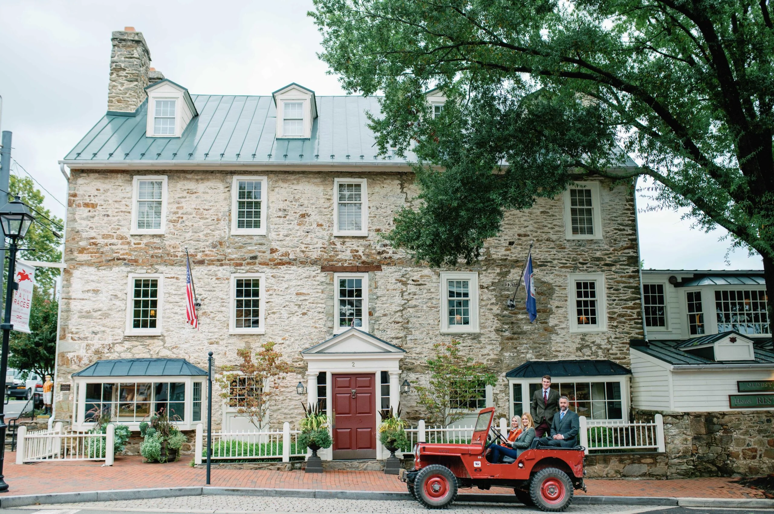 Charming historic inn and tavern exterior surrounded by trees, inviting guests to experience classic.