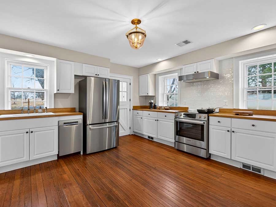 Bright Cedar Cottage kitchen featuring stainless steel refrigerator and stove.