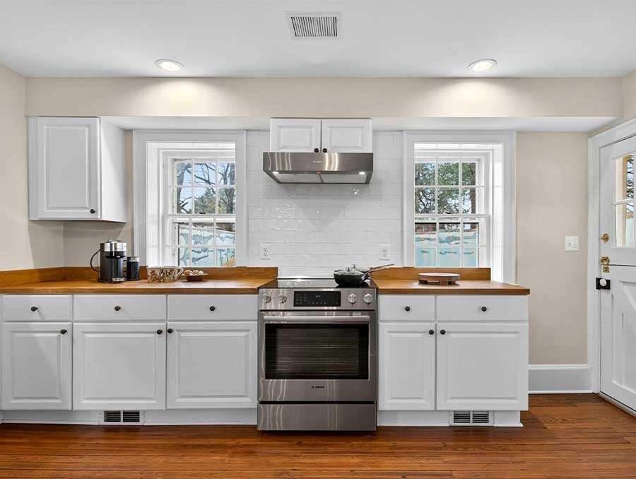 Cozy kitchen with white cabinets, wooden countertops, and stainless steel appliances at The Red Fox.