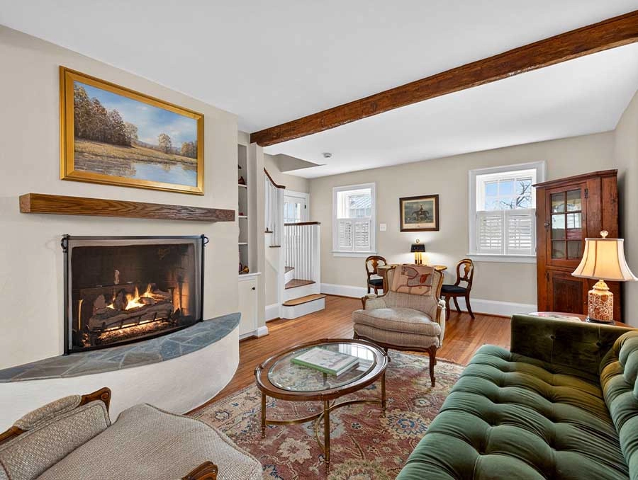 Interior view of a cozy living room at The Red Fox Inn & Tavern, featuring a fireplace, vintage furn.