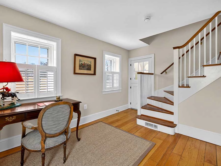 Bright living space with white walls, wooden floors, and classic decor.