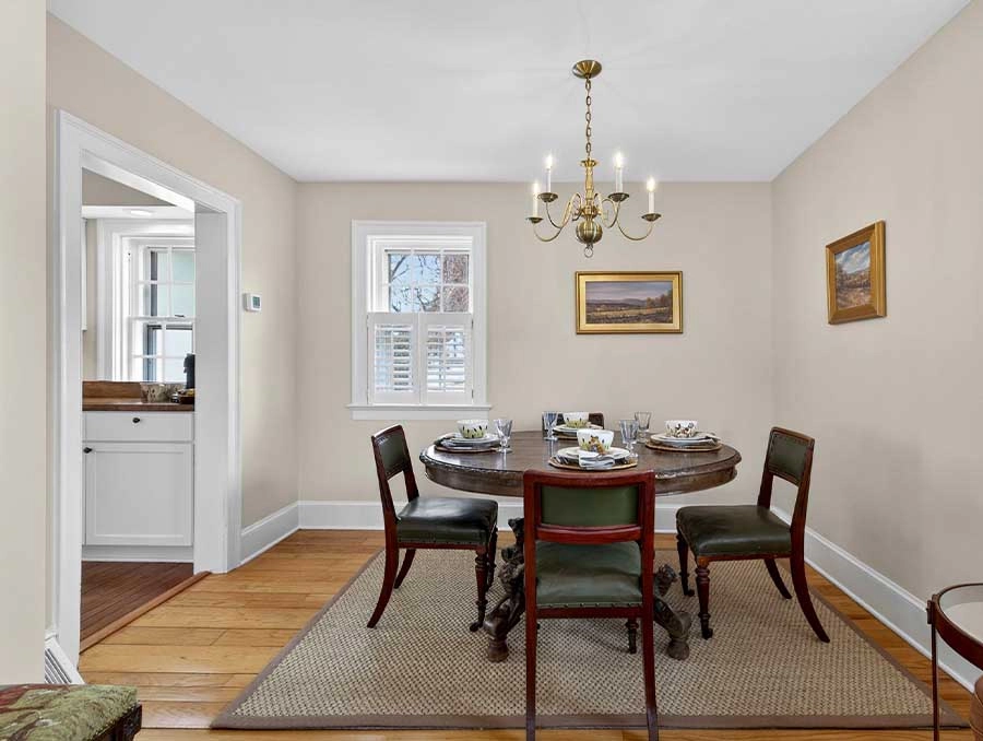 Charming dining room with a round table, elegant chandelier, and classic decor at The Red Fox Inn &.