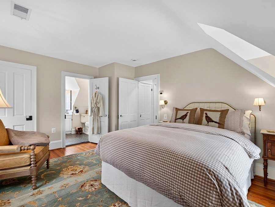 Comfortable bedroom with a large bed, armchair, and soft lighting at The Red Fox Inn & Tavern.