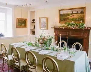 Elegant dining room setup with a long table, floral centerpiece, and candles.
